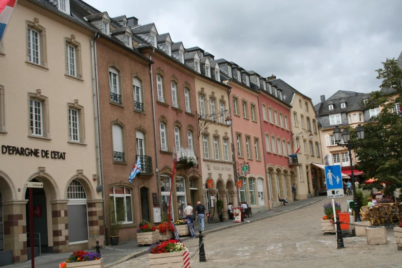 colorful buildings line a narrow street with a couple of people walking by