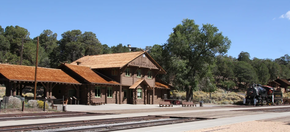 a train engine pulling into a station with a brown roof