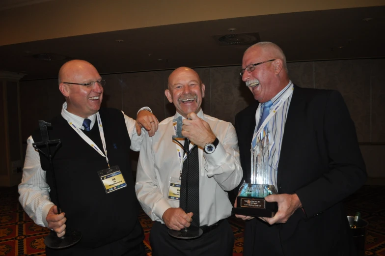 three men standing next to each other posing for a po