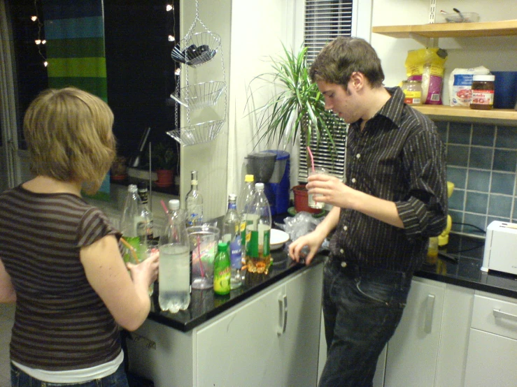 the two men are preparing a lot of beverages together