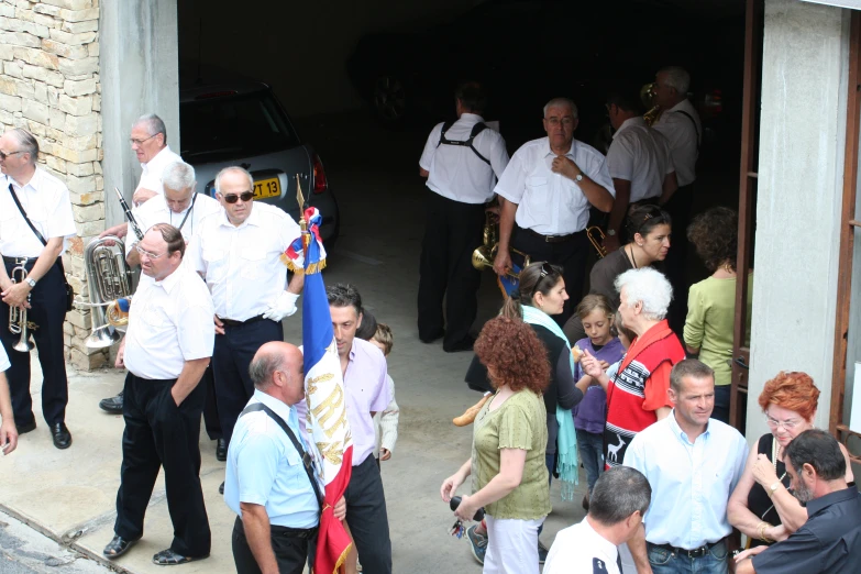 several people in white shirts some holding flags and microphones