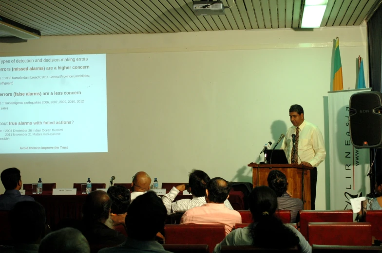 a man stands at a podium in front of an audience