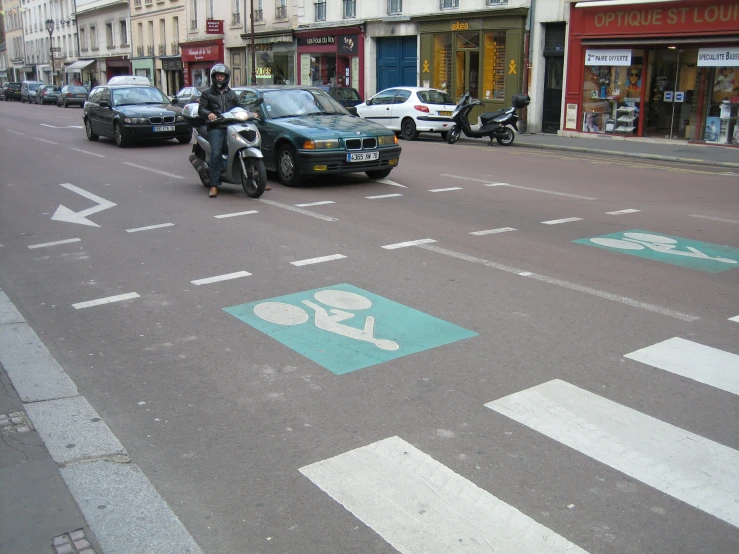 a motorcycle driving down a road with people and cars