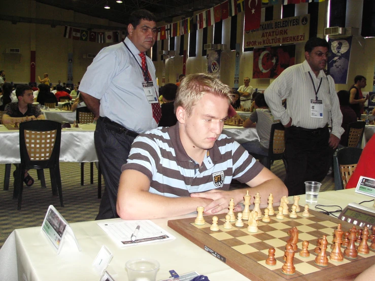 man at table playing chess during conference in building