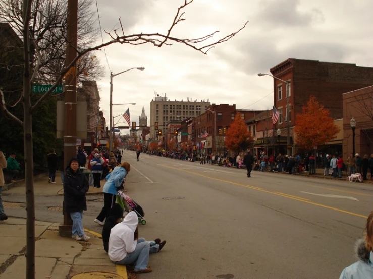 people sitting on the sidewalk on a street corner