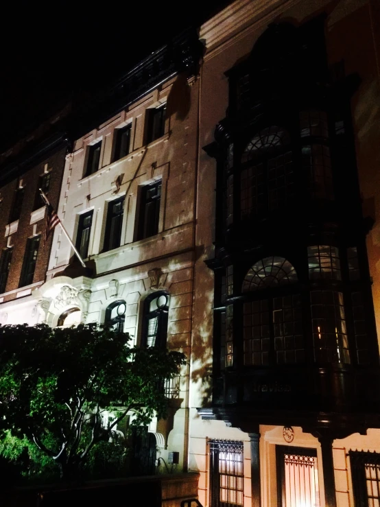 a very large house that is lit up with a clock on it