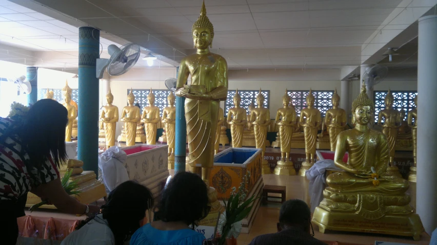 people looking at gold statues in a store