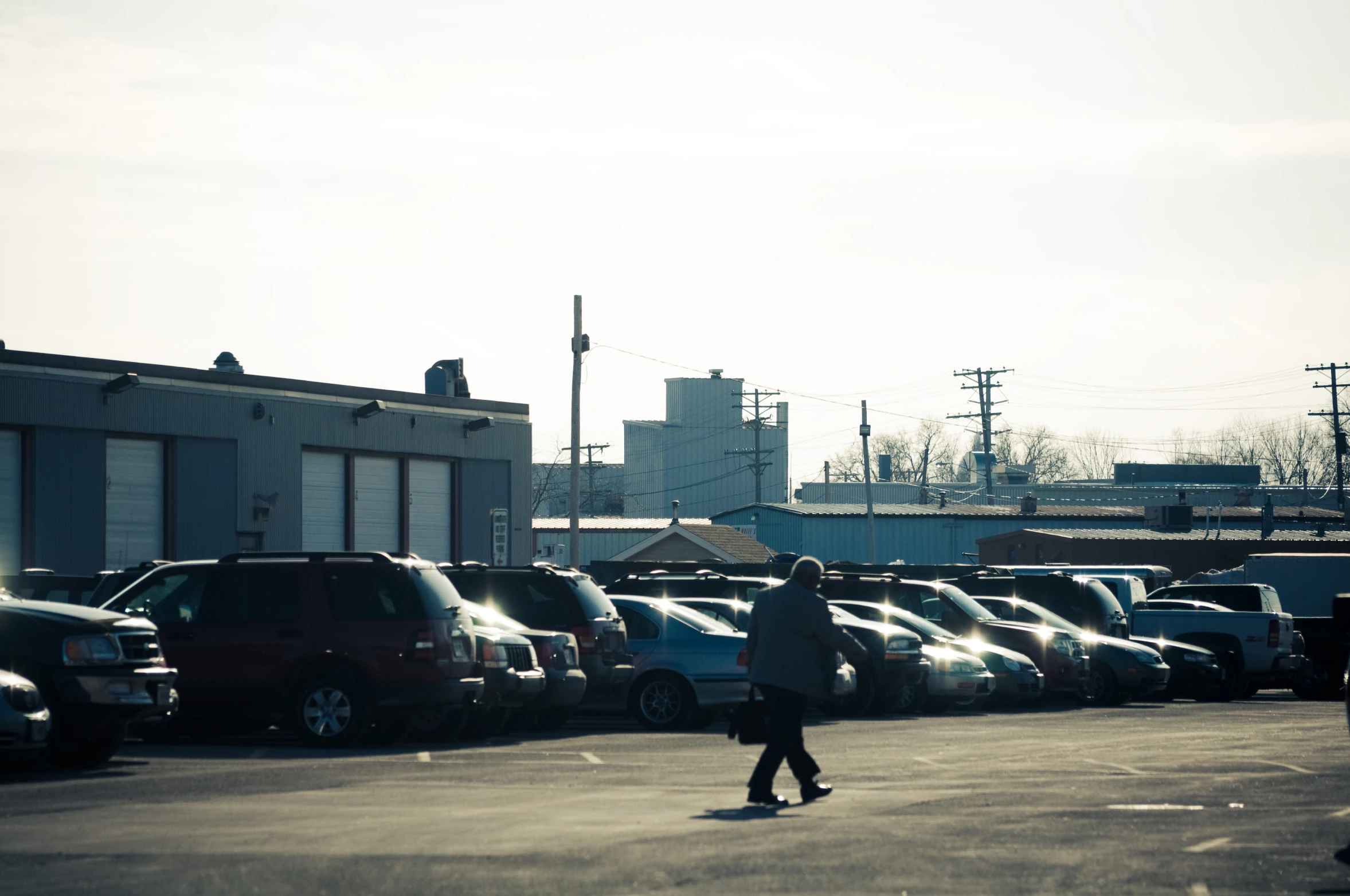 a woman riding on top of a skateboard across a parking lot