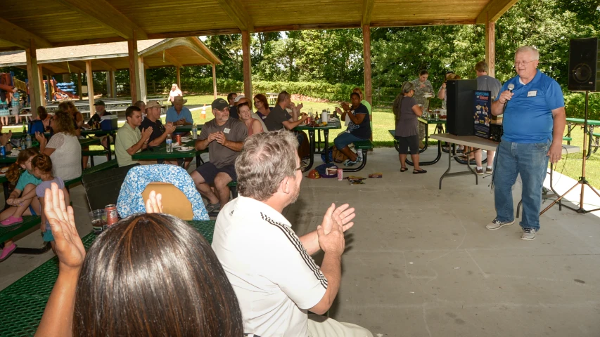 a group of people gathered on a patio for a community meeting