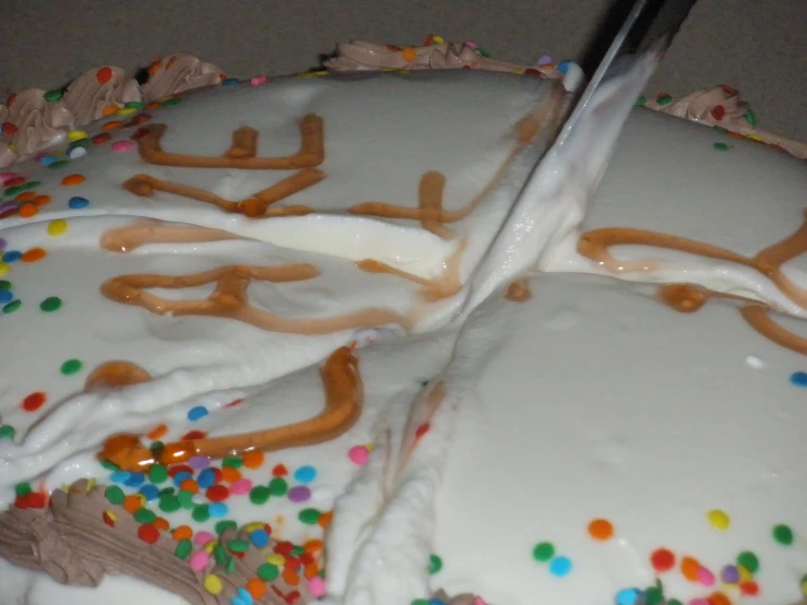 two cakes decorated with sprinkles, frosting and forks