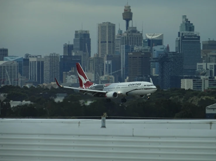 an airplane is flying over a building and a city