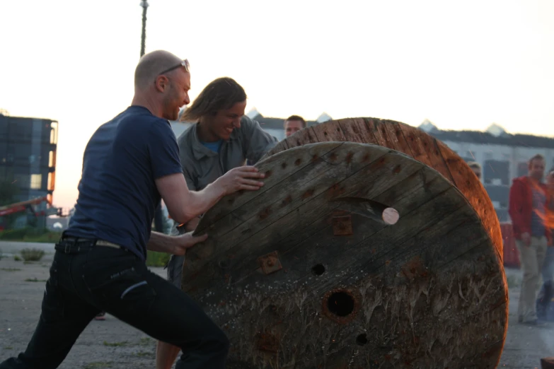 a man and woman working with a large spool