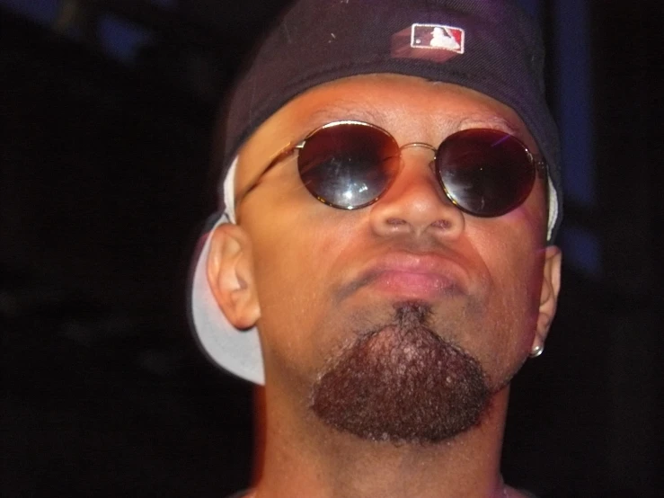 a close up of a person wearing sunglasses and a hat