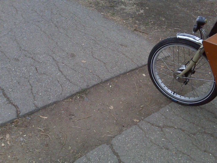 the front wheel of a bike is facing an orange box