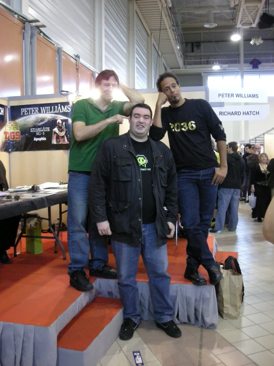three guys at a trade show posing for a picture