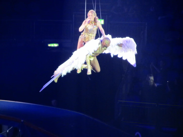 two woman dressed as an angel perform on aerial stage