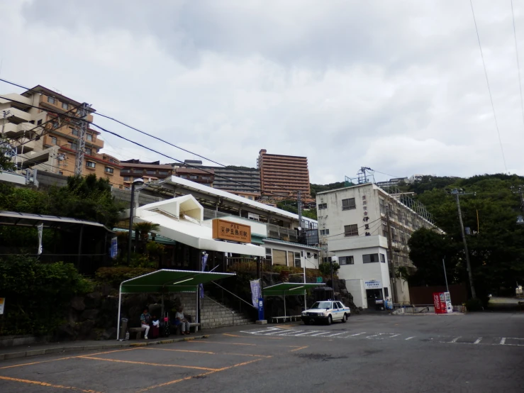 a white van sitting next to a hillside with buildings