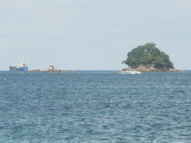 an island with two boats in the distance