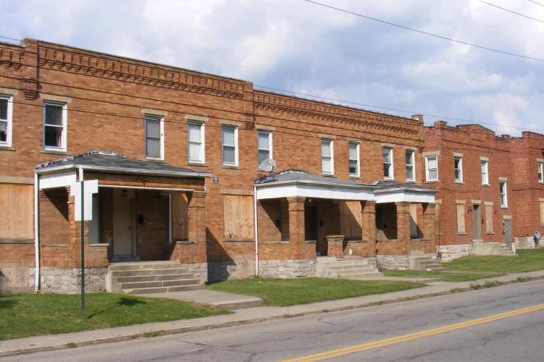 many red brick houses are in disrepair on the street