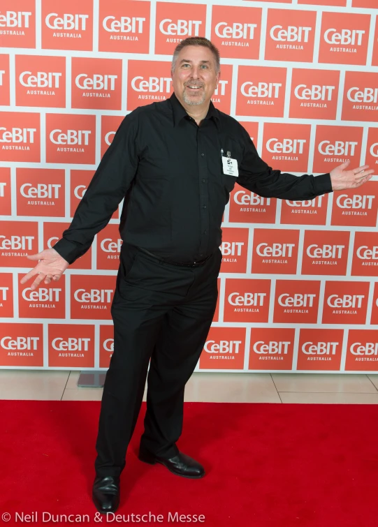 a person on a red carpet in a black dress shirt