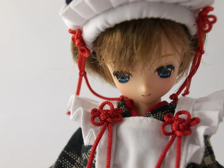 an open doll eyes, blue eyes and red hair, wears a dress with a white cap