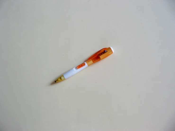 an orange and white pen sitting on a table