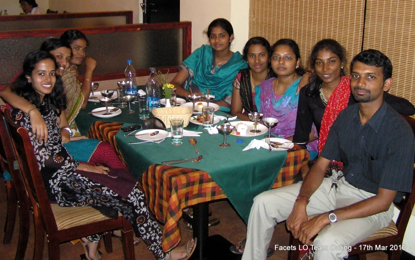 a group of women and men at a table smiling at the camera