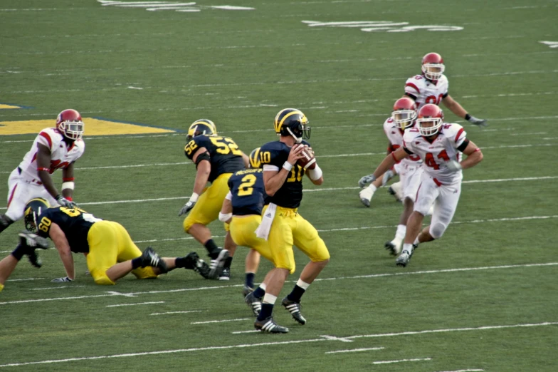 three teams running with a ball and two football players in uniform