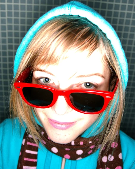 a girl wearing sunglasses and a scarf around her head