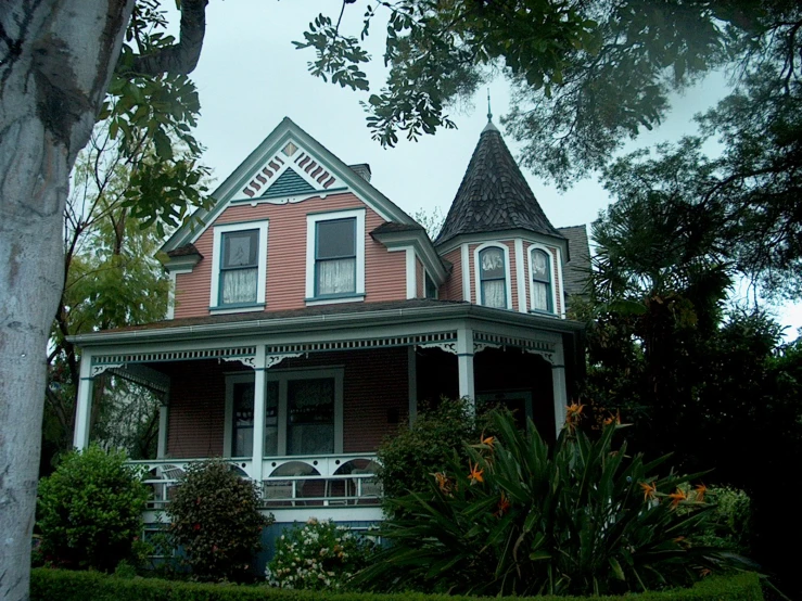 an old victorian pink house in the middle of the fall