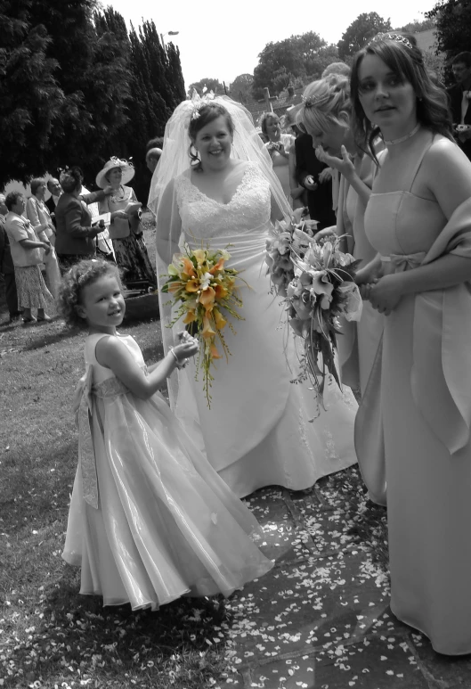 people in wedding gowns are holding flowers and posing for a po