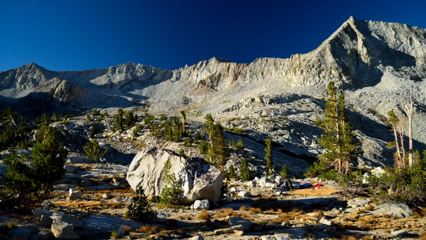 a rocky mountain range with a rock formation on the ground