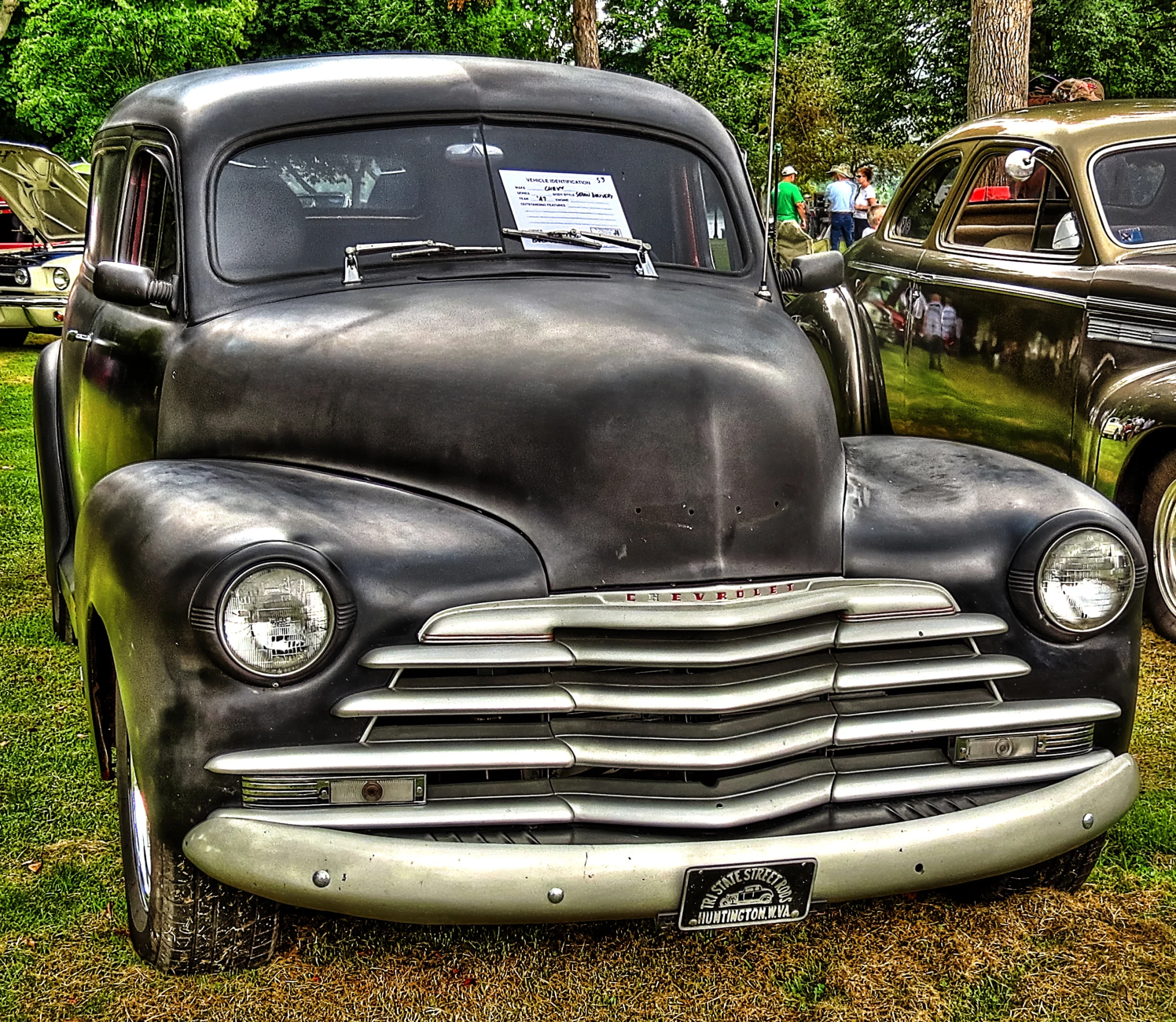 old vehicles in a line in grassy area