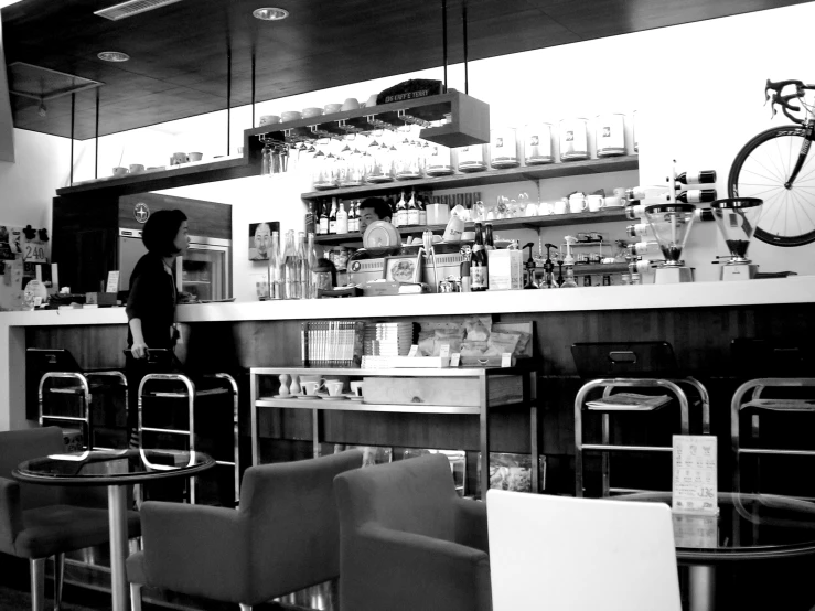 a counter with chairs, shelves, and some shelves