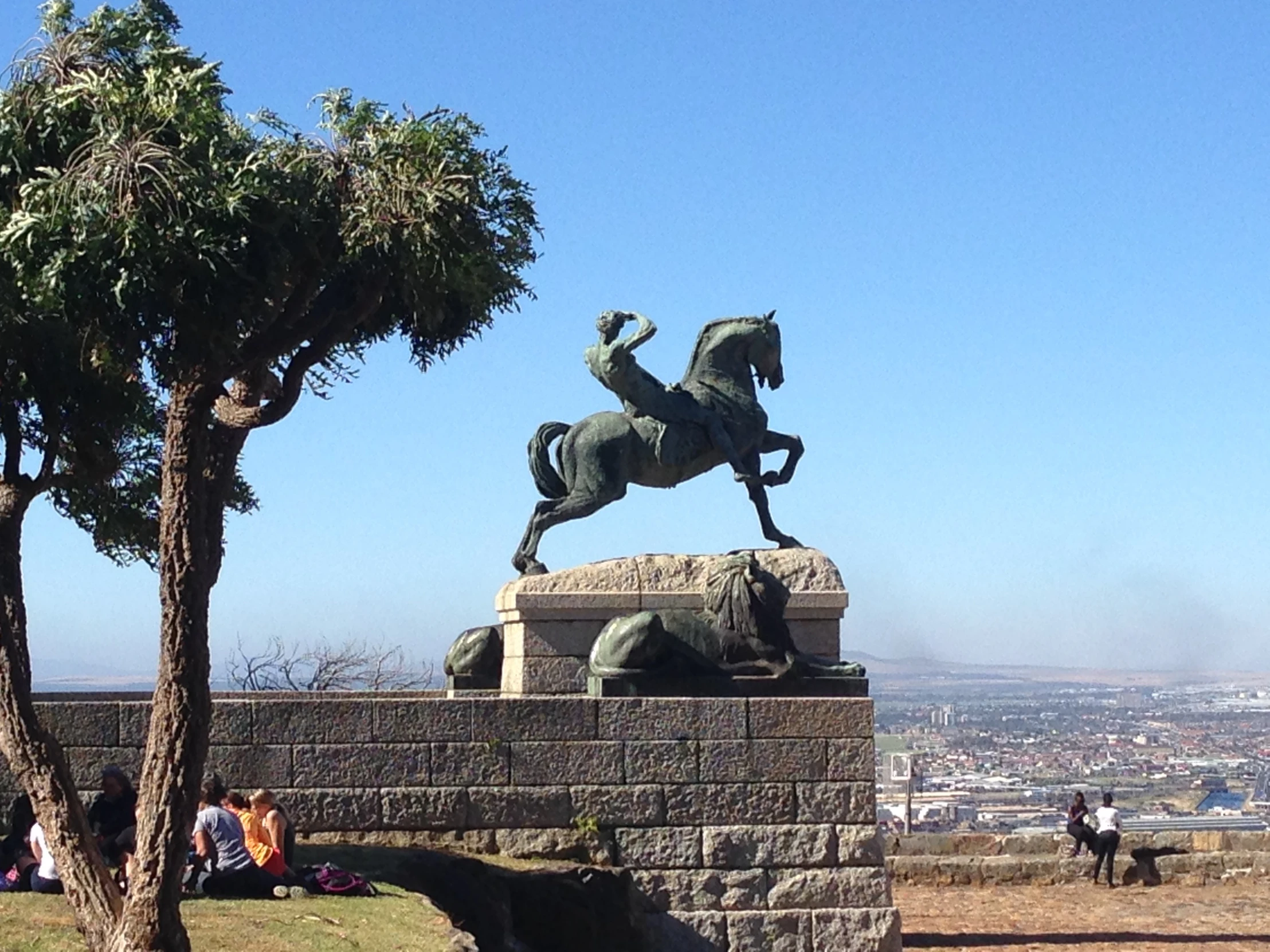 a statue of a man on horseback that is in front of a tree