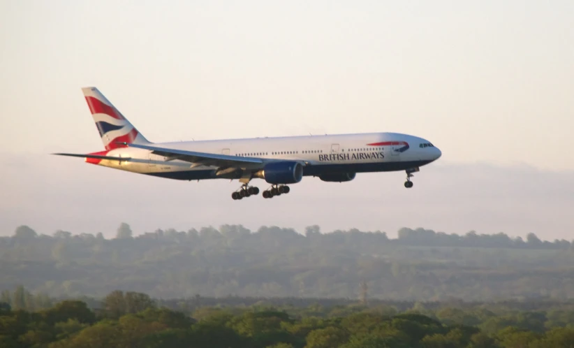 an airplane takes off as the sun begins to set