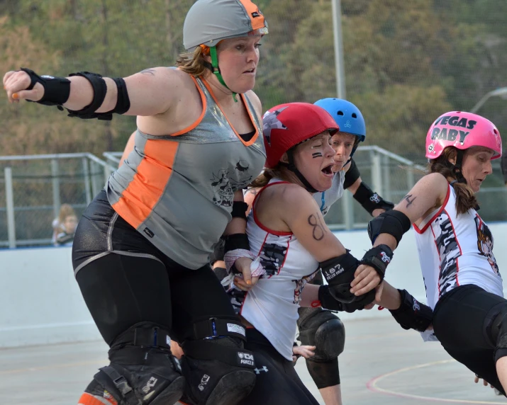 several girls with helmets playing in an empty paddock