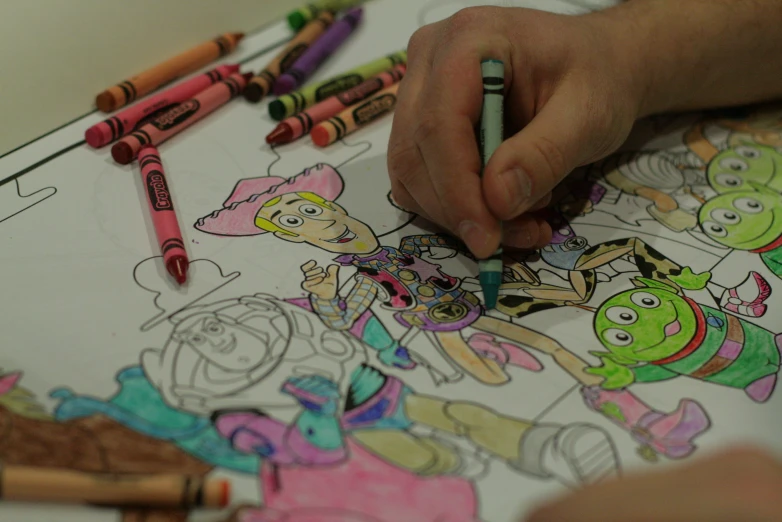 a child's hands coloring an image with crayons