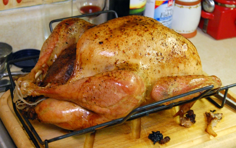 chicken on a grill pan and surrounded by roasting accessories