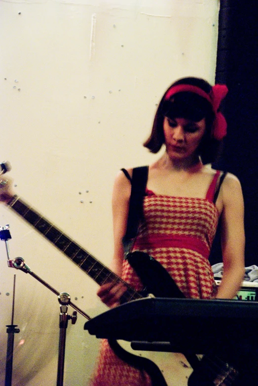 a girl standing by a drum set and a musical instrument