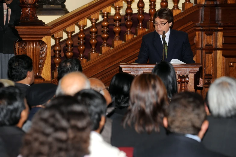 the man is standing at the podium, in front of an audience