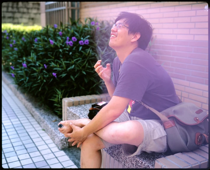 a guy sitting on the bench eating food