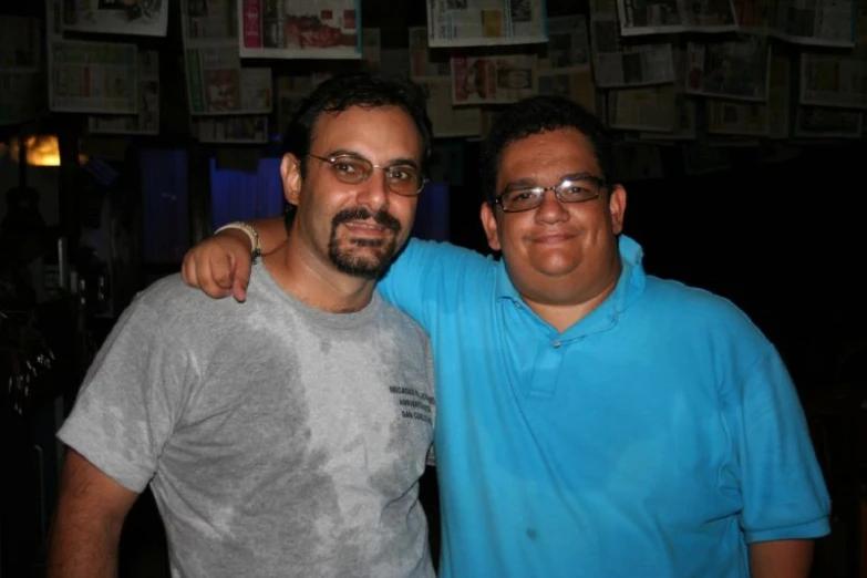 two men smiling at the camera in a bar