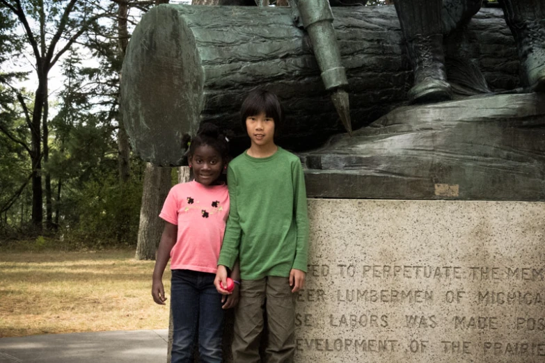 two children stand in front of the monument