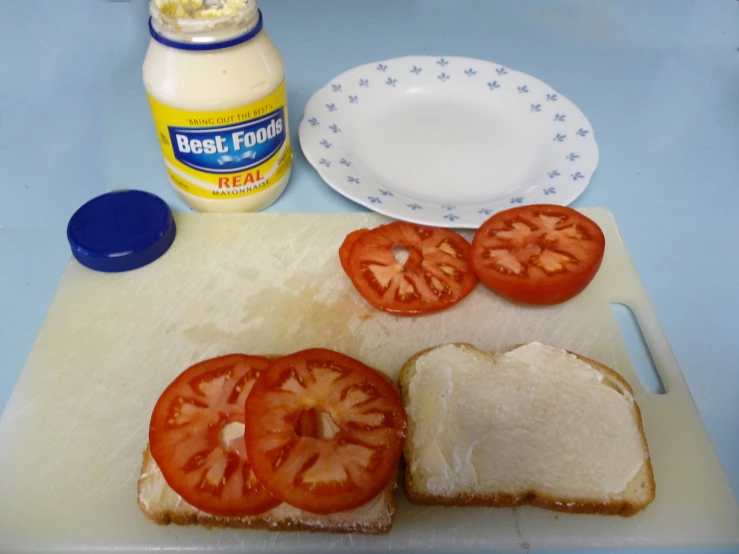 a  board topped with sandwiches next to a bottle