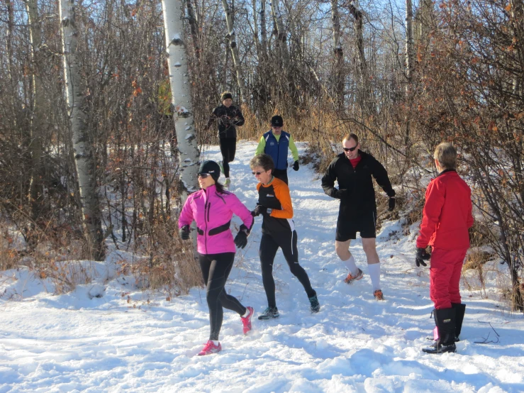 young people are running in the snow on the trail