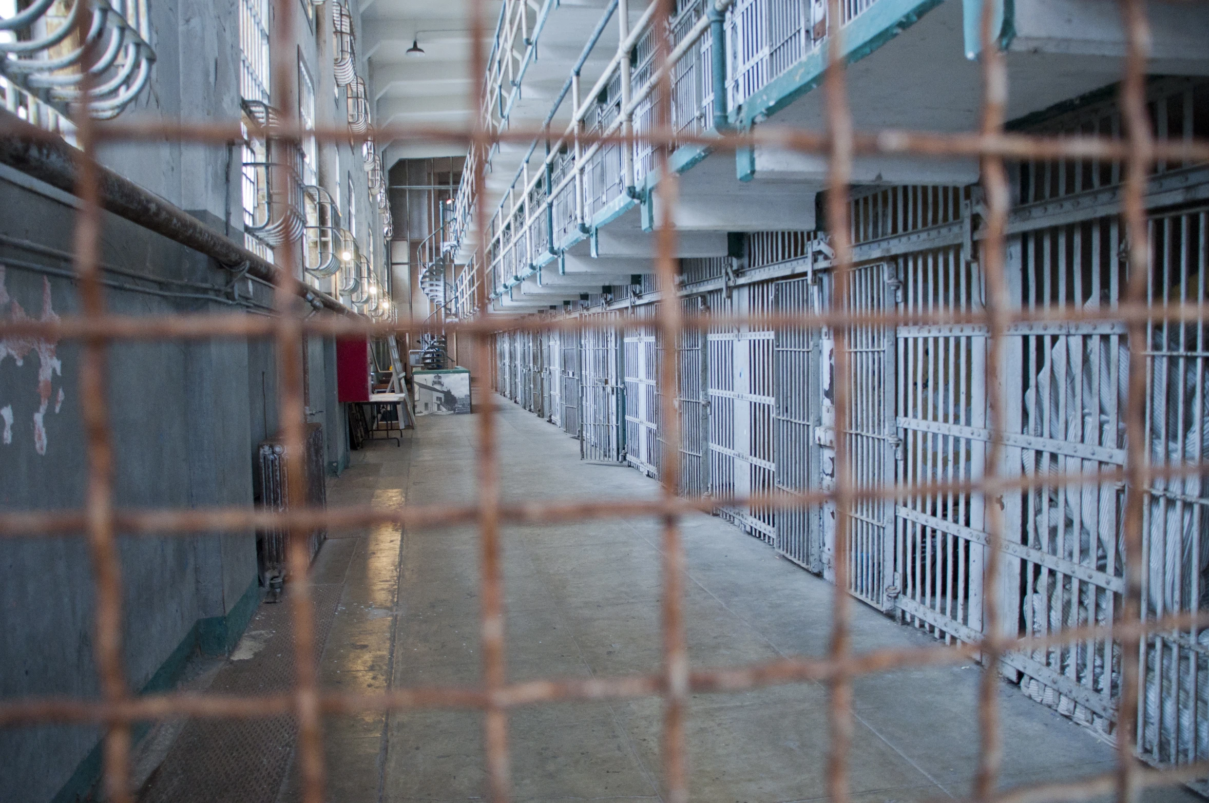 this is a po looking through a fence at some prison cell block