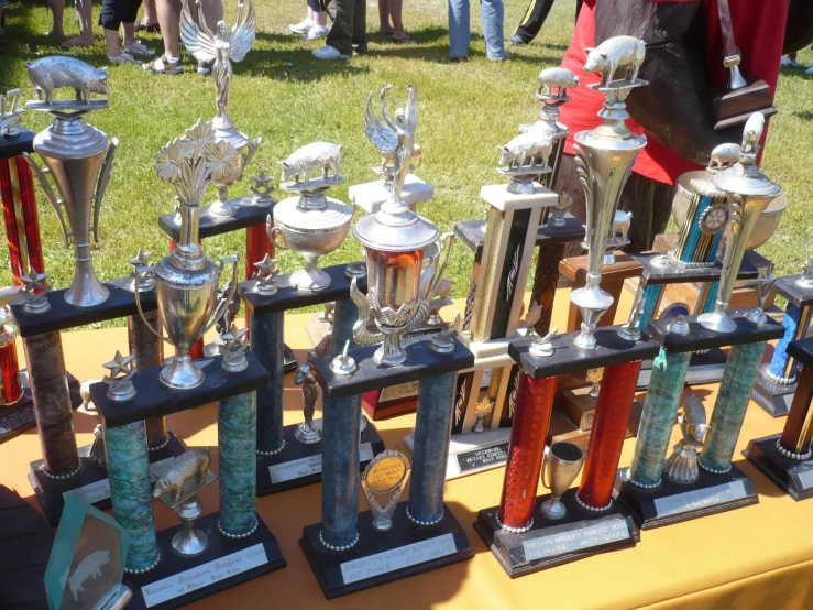 many silver and red trophies and a yellow table cloth