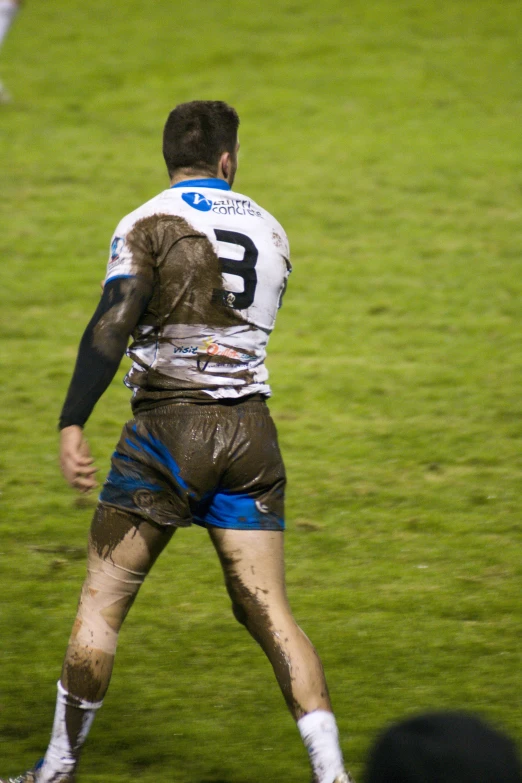 a guy walking in the mud with a frisbee