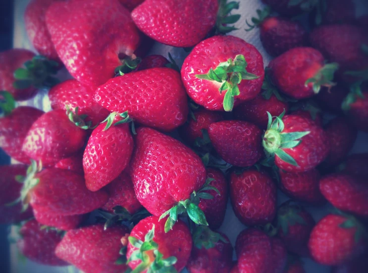 some very pretty looking strawberries that are grouped together